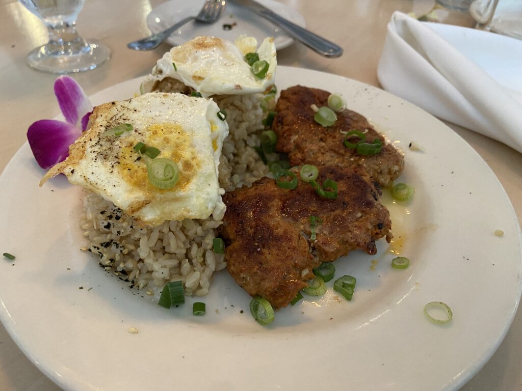 The two homemade Linguisa Portuguese sausage. The two eggs are placed on top of the brown rice mounds with green onions.