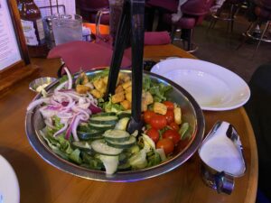 House Sale with romaine lettuce, baby tomatoes, red onions, cucumbers, and croutons.