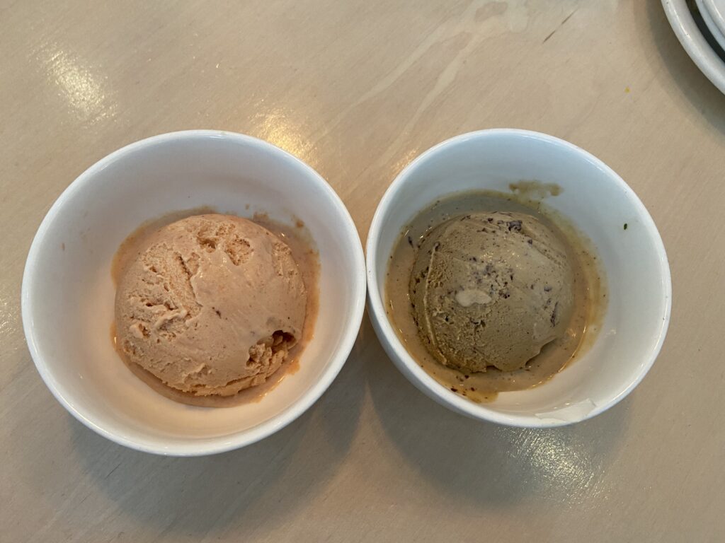 To the Left is a bowl of single-scoop guava ice cream. To the Right is a bowl of single-scoop Kona coffee ice cream.