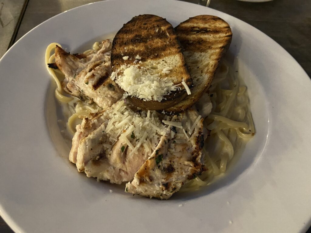 Alfredo Pasta with chicken and two pieces of toasted bread with grated parmesan.