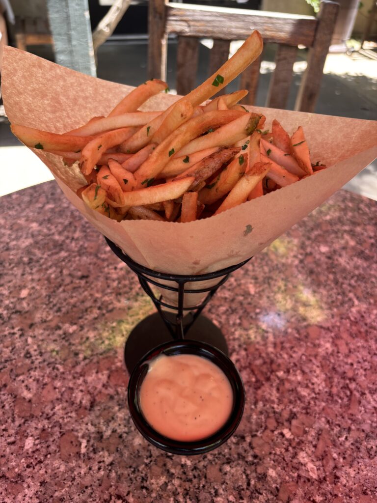 French fries with white truffle oil topped with parsley with a side of malt vinegar aioli.