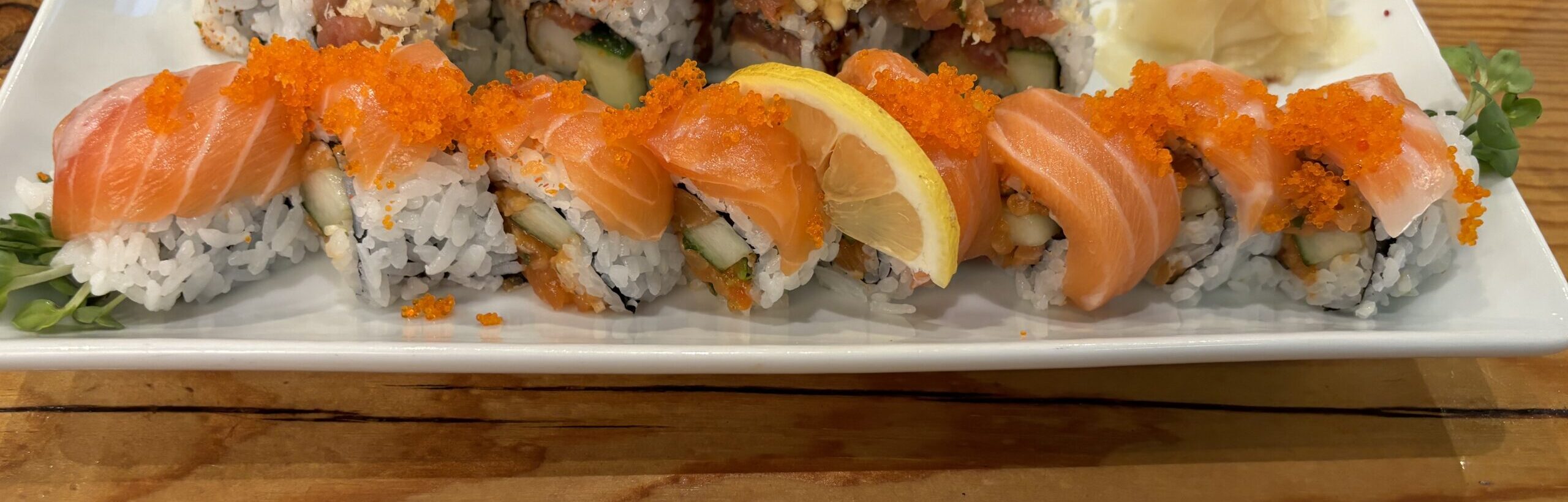 Super Salmon - spicy salmon, cucumber, radish sprouts roll topped with salmon slices and tobiko